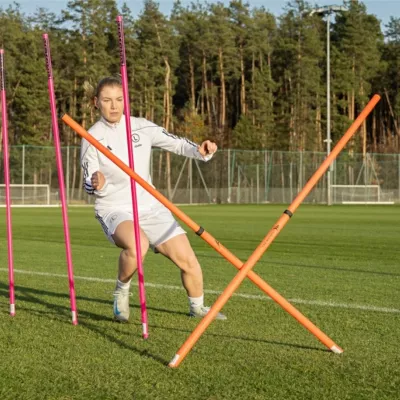 Trening zwinności piłkarskiej z użyciem tyczek teleskopowych o grubości 33 mm.